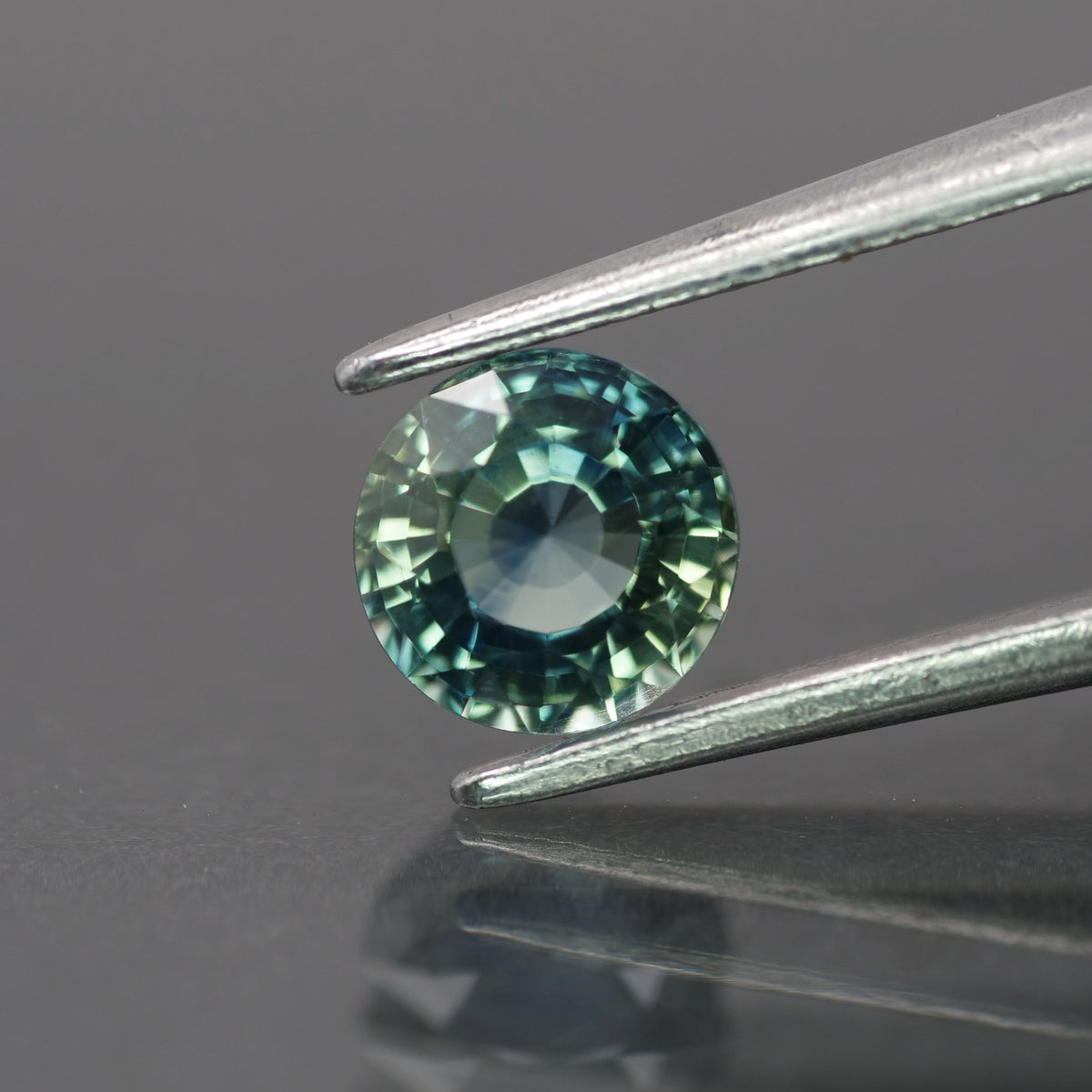 Sapphire | natural, teal color/color changing, round-cut, *5.5mm, 0.9ct