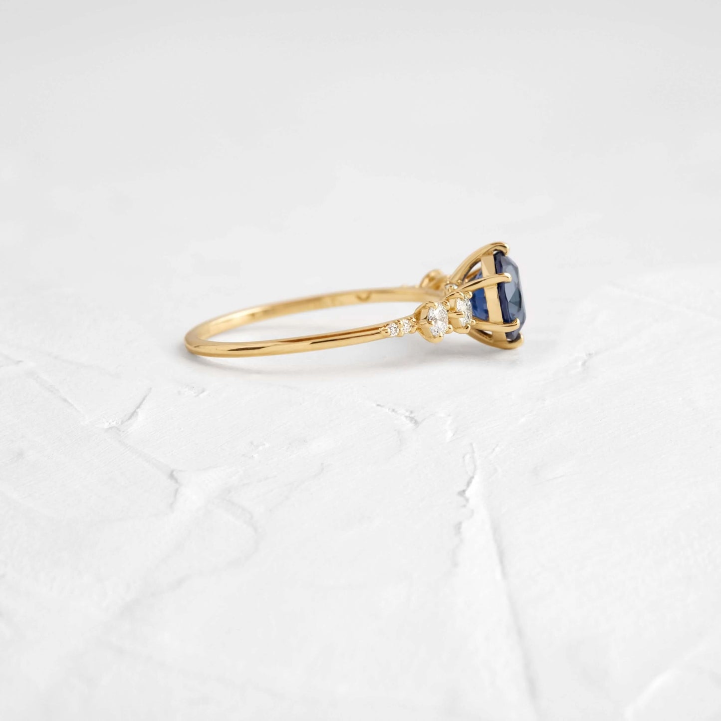 This engagement ring features 925 sterling silver with yellow gold plating, set with a deep blue round cut blue stone, exuding classic and noble elegance