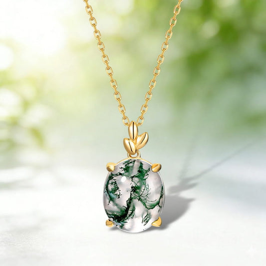 Oval pendant with green branching patterns, gold-tone prongs and a leaf-shaped bail.