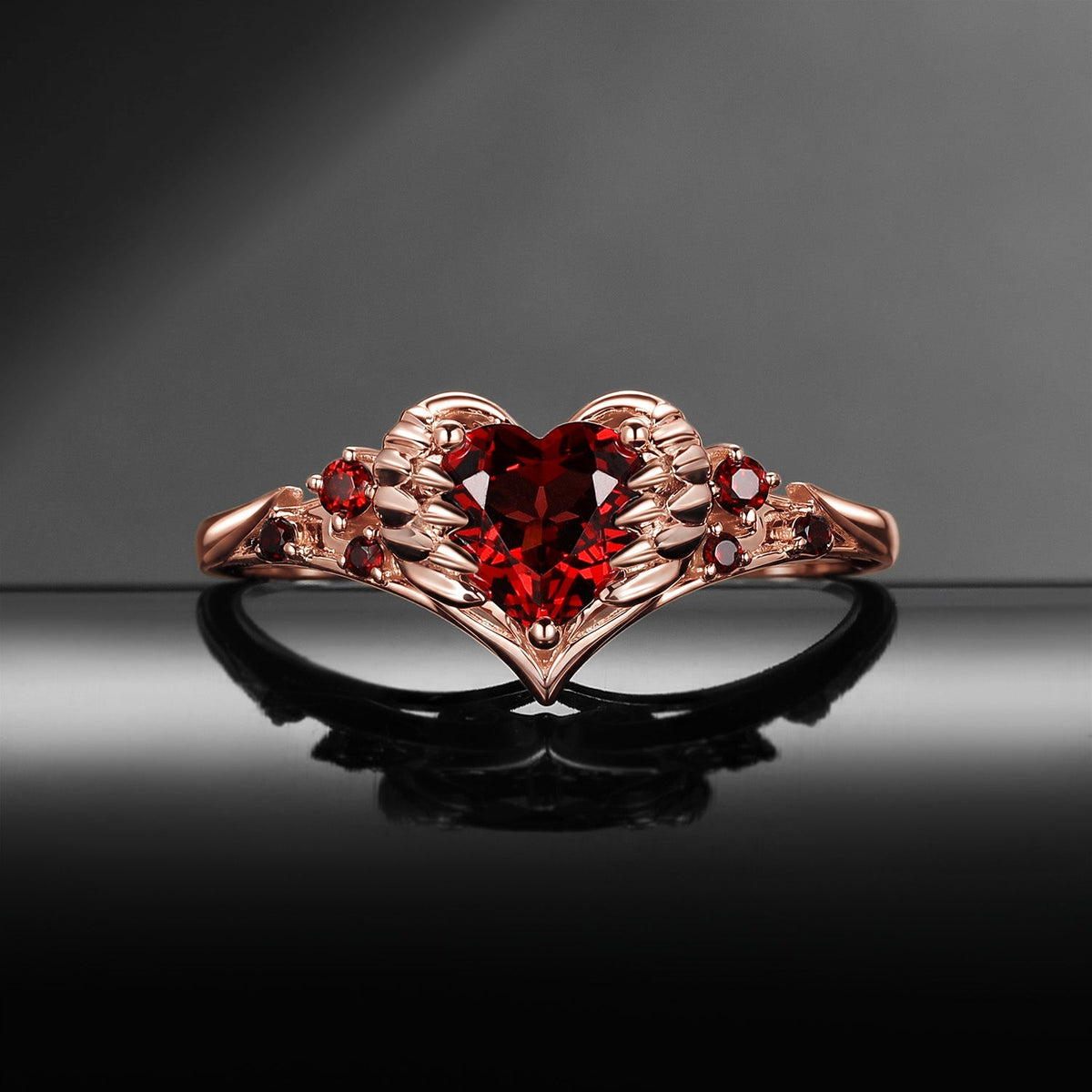 Heart & Sword 'Pierced Heart' – Gothic Garnet Engagement Ring with Angel Wing Detail
