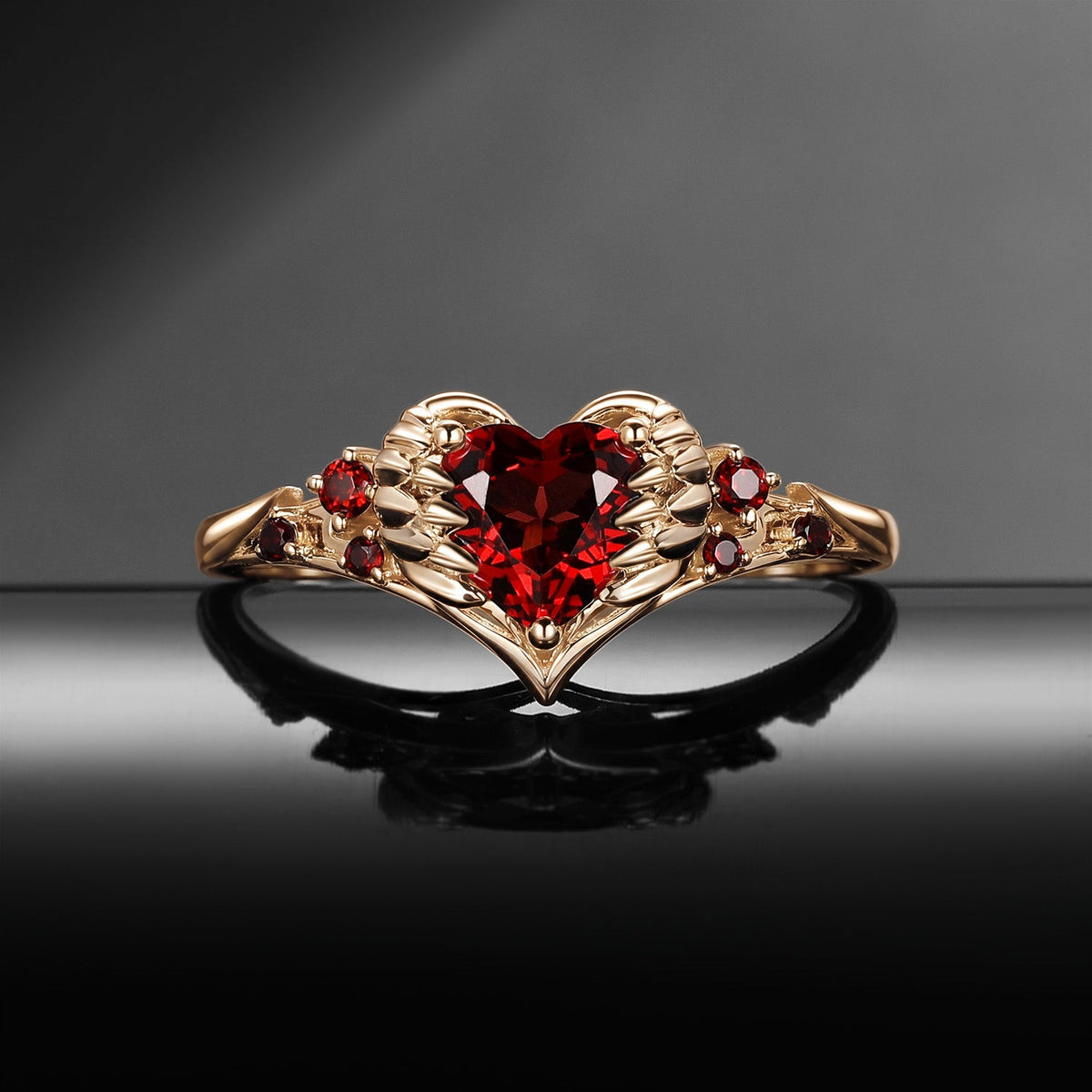 Heart & Sword 'Pierced Heart' – Gothic Garnet Engagement Ring with Angel Wing Detail