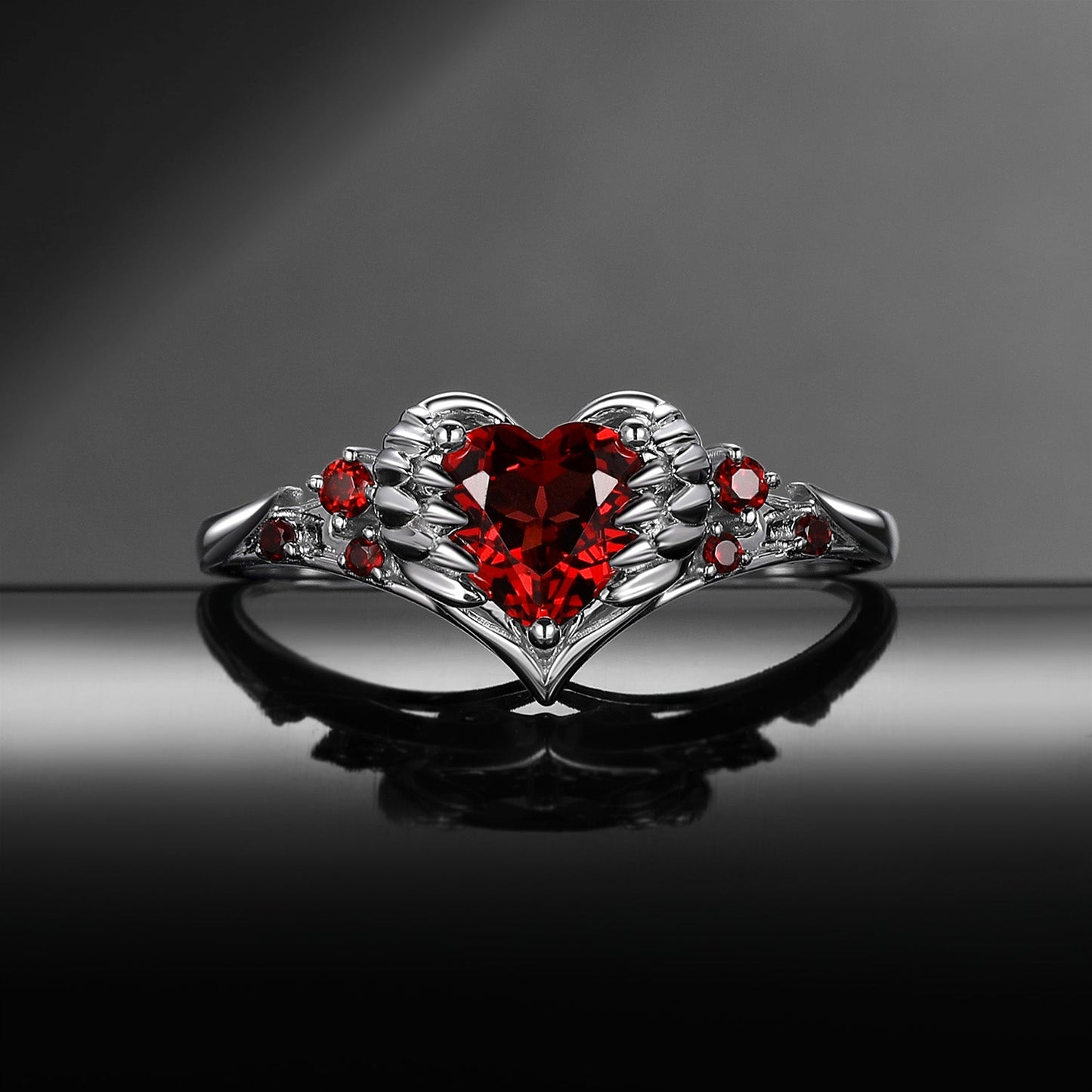 Heart & Sword 'Pierced Heart' – Gothic Garnet Engagement Ring with Angel Wing Detail
