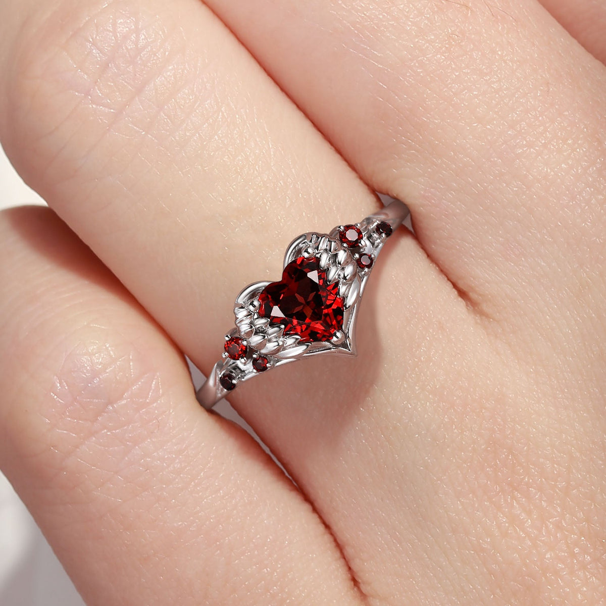 Heart & Sword 'Pierced Heart' – Gothic Garnet Engagement Ring with Angel Wing Detail