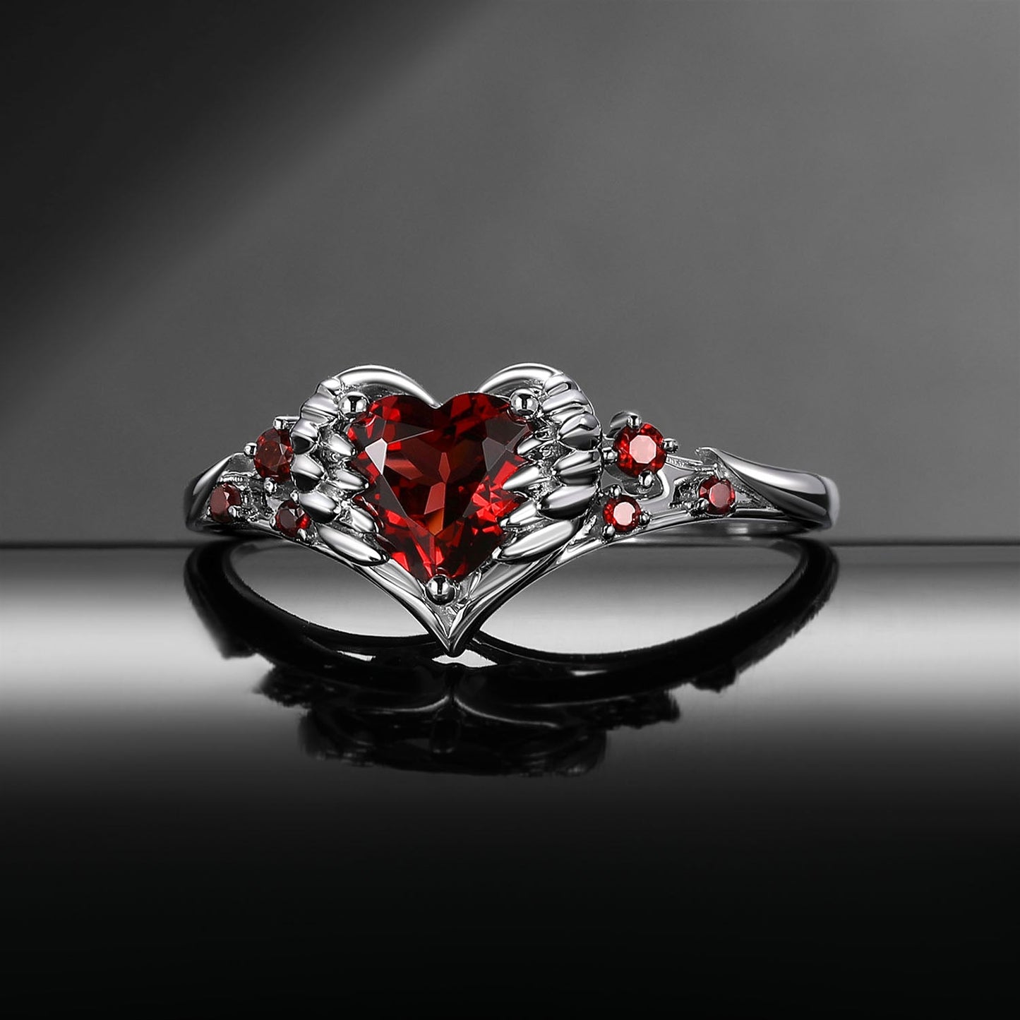 Heart & Sword 'Pierced Heart' – Gothic Garnet Engagement Ring with Angel Wing Detail