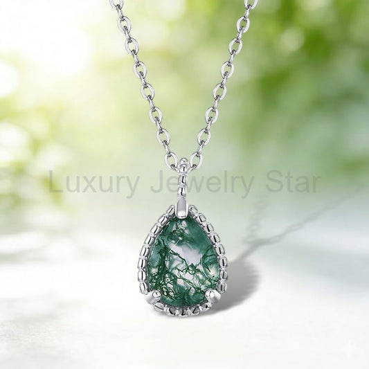 Pear-shaped green-patterned pendant with a silver-tone beaded border and chain against a blurred