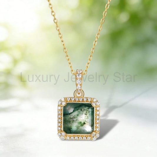 Square green-patterned pendant with clear halo accents, a gold-tone frame and chain against a