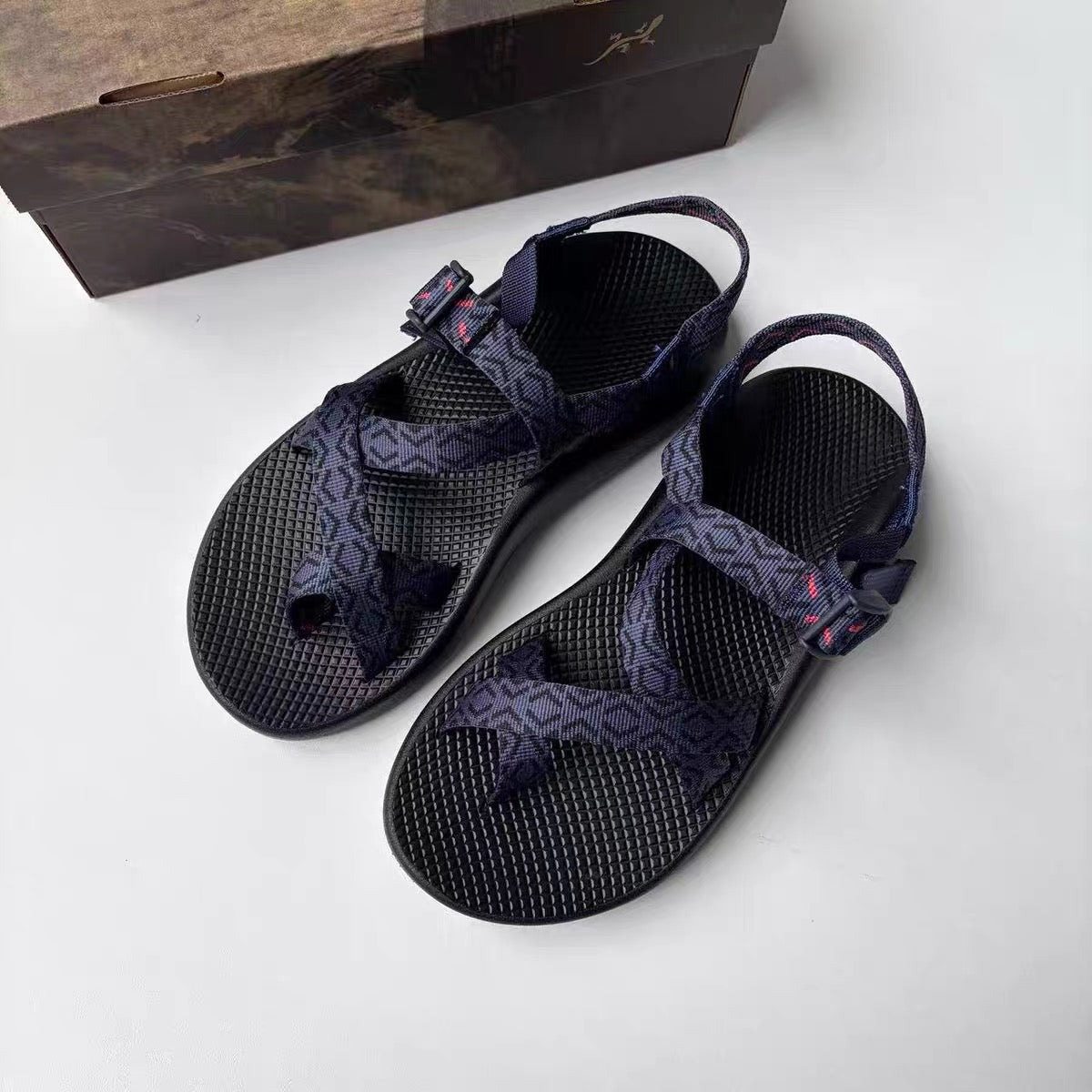Pair of navy patterned Chaco Men's Z2 Classic outdoor sandals laid flat next to the original shoe